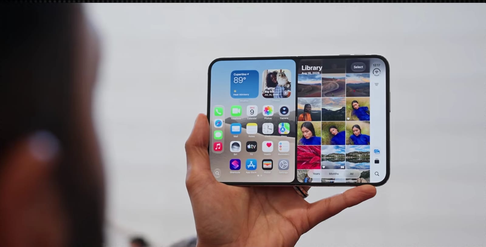 The iPhone 17 Pro Fold unfolded, showing the home screen beside the Photos library in a split layout.